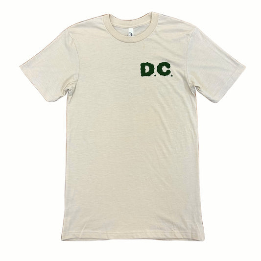 Beige t-shirt with 'D.C.' printed in green on a white background