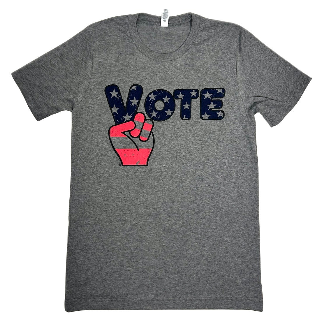 A heather gray short-sleeve t-shirt featuring a 'VOTE' graphic on the chest. The letter 'V' is a peace sign filled with white stars on a navy blue background, and the remaining letters are filled with a red pattern.